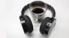 A cup of coffee inside a pair of over-ear headphones on a table